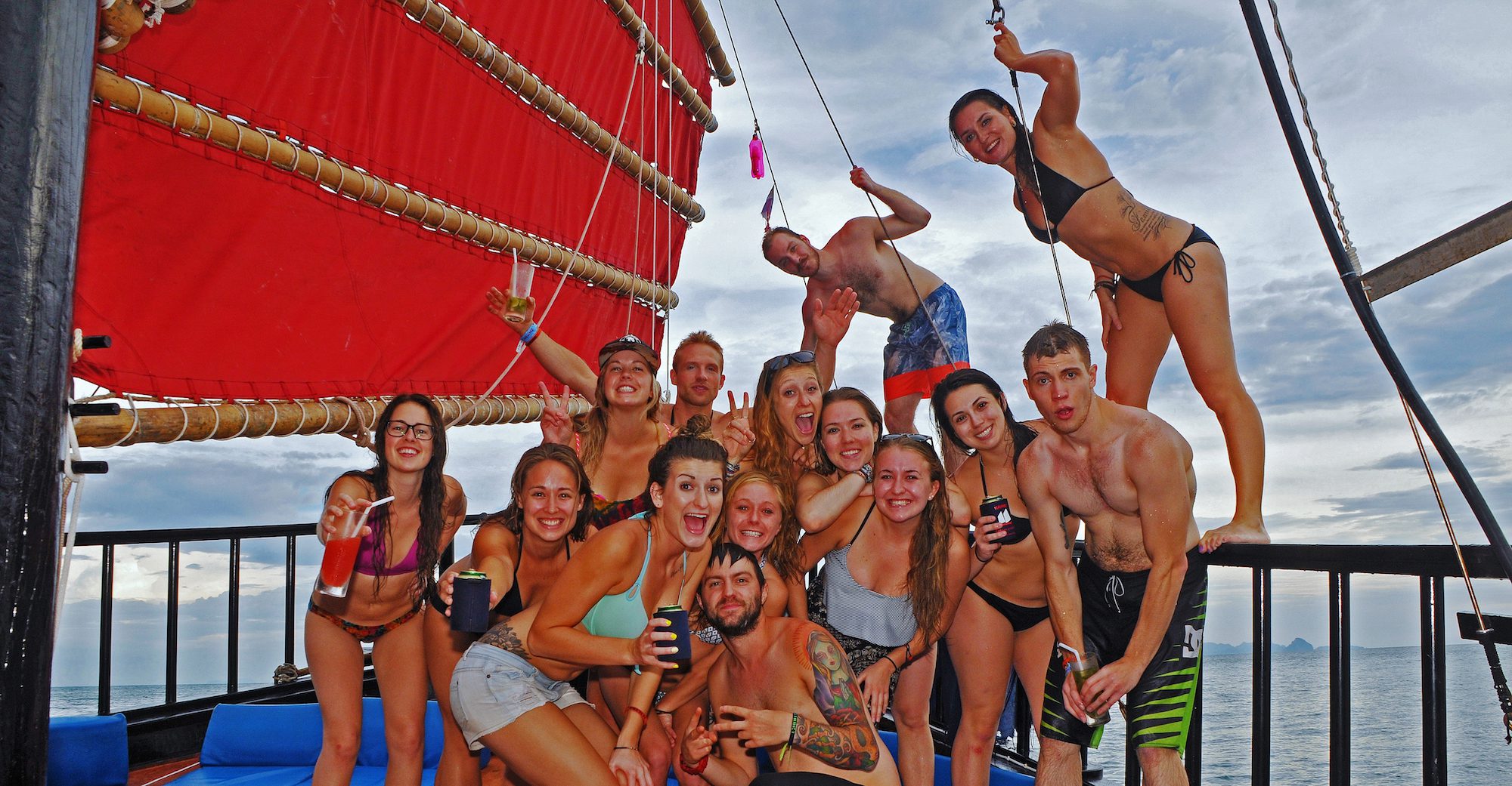 Group photo of people on a Krabi Sailing Tour with the boats larger red sail to the left