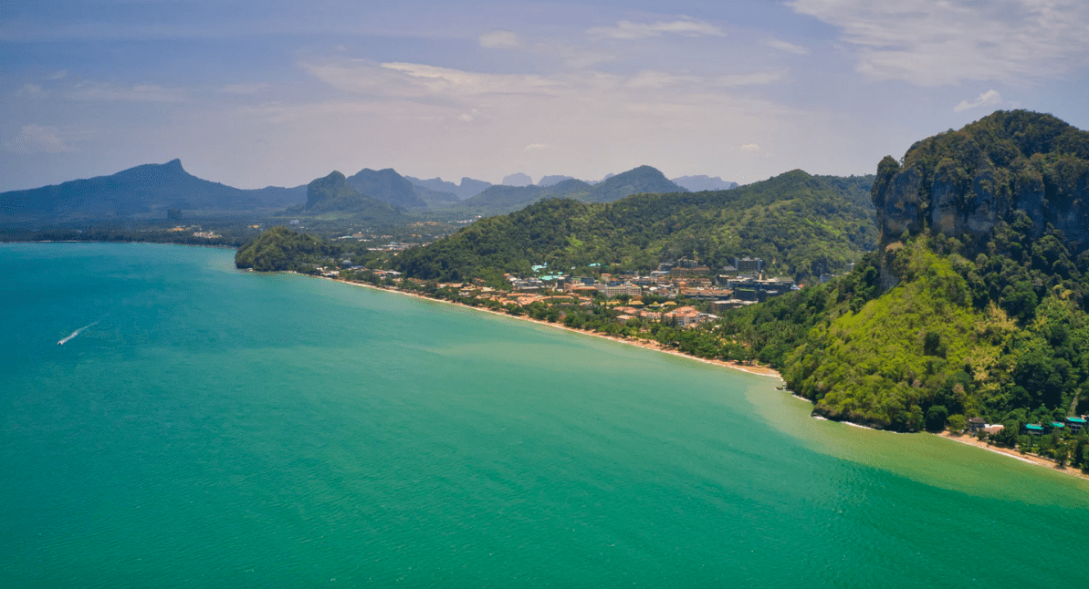 Drone photograph looking along the beach of AoNang, surrounded by mountians