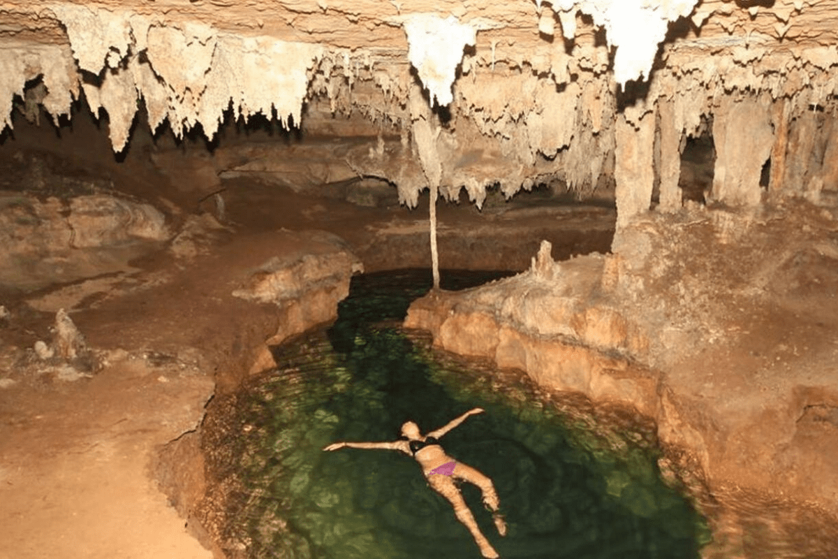 A woman floating in the shallow pool in the caves in Ao Luek, Krabi, Thailand