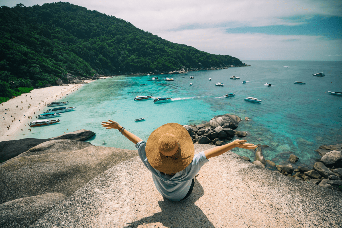 Overhead view of someone sitting on a viewpoint rock looking across a beach in Phuket