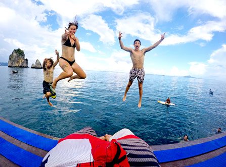 POV photo of guests posing jumping off the boat into the water during a Krabi Private Morning Cruise with islands in the background