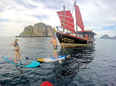 Guests posing on paddle boards in front of boat during Krabi Private Morning Cruise with islands in the background