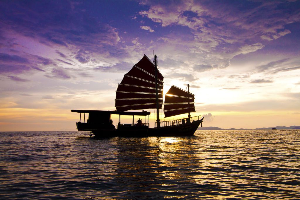 Silhoutte of guests on a Krabi Sailing Tour boat on a Krabi Sunset Cruise with sunset in the background