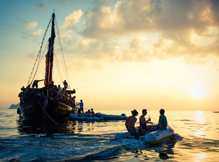 Silhouette of a group of guests enjoying the 4 Island Sunset Cocktail Cruise and Bioluminescent Night Snorkel on board a Krabi Sailing Tour boat