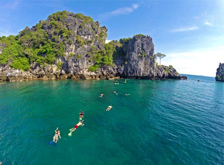 Group of people snorkling with islands in the background