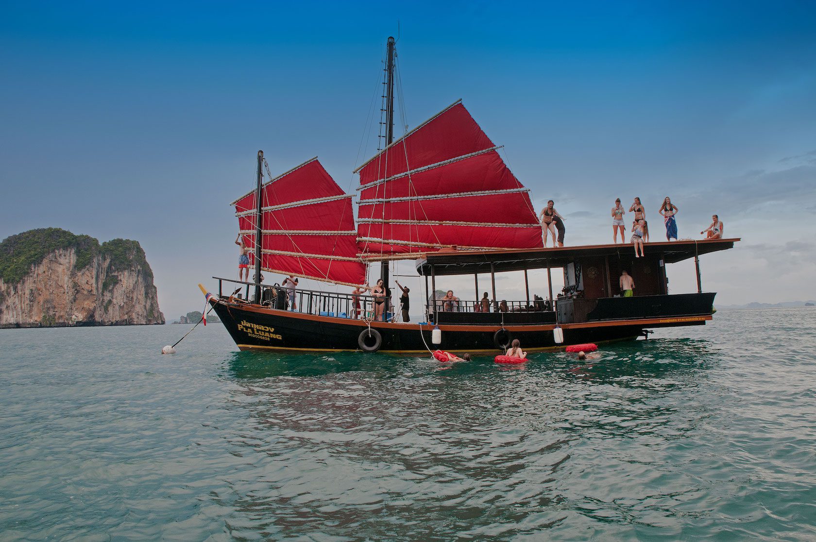 Image of guests on boat and in water during a Krabi Private Morning Cruise with islands in the background