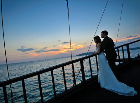 Silhouette image of married couple looking out to sea onboard Private Cruise in Krabi with sea and sunset sky in the background