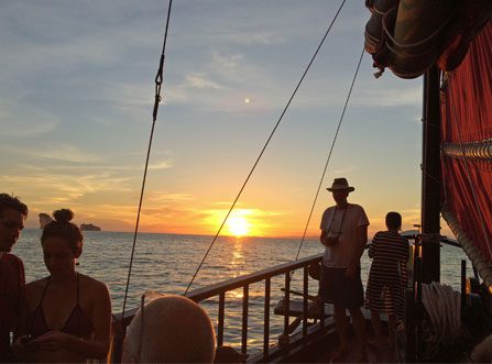 Silhouette image of guests onboard Krabi Sunset Cruise with sun setting in the background