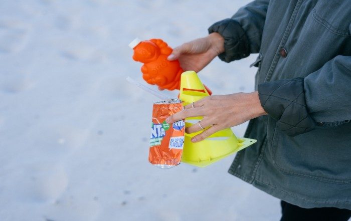 Hands collecting rubbish from the beach