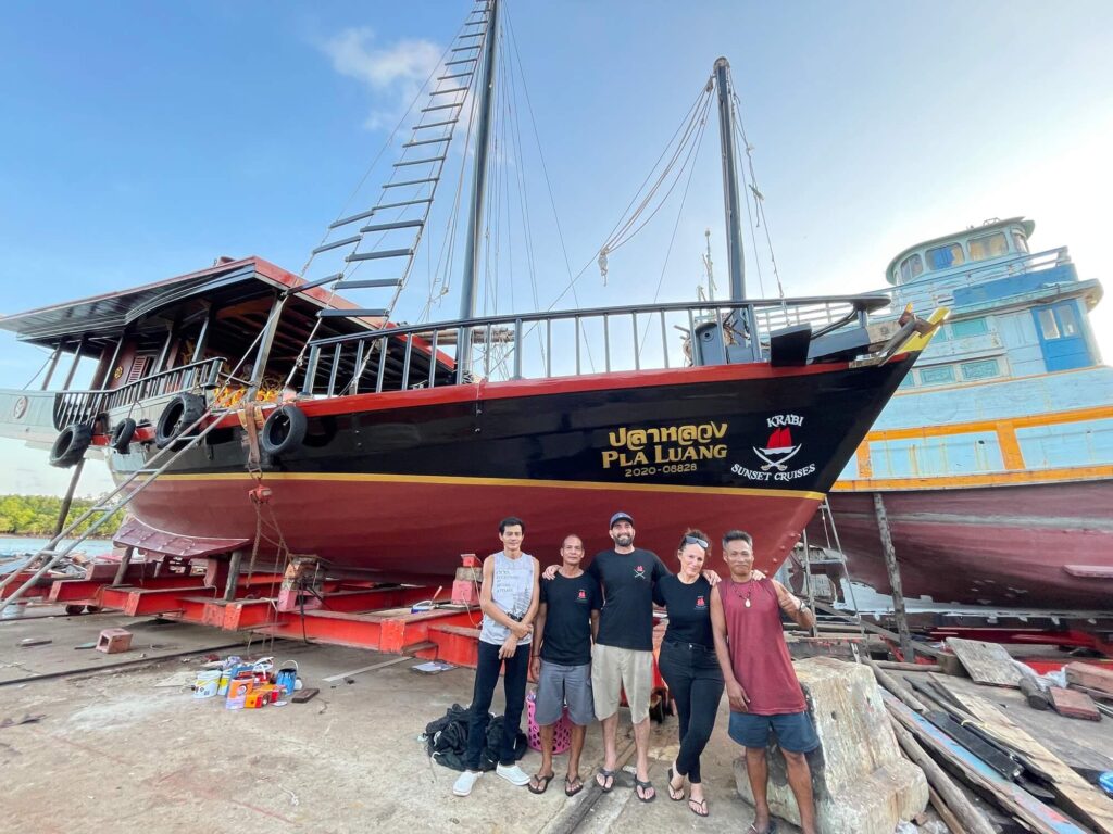 krabi sunset cruise team standing in front of their pirate ship tour boat