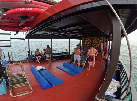 Invités debout et discutant près du salon et sous le toit. Planches à pagaie sur le toit.