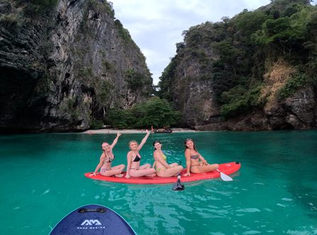 our women on a paddleboard posing in a hidden beach at Poda Island