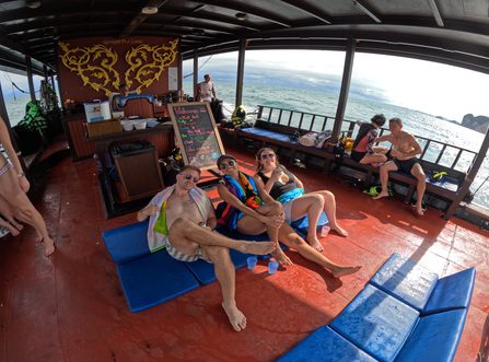 Les invités se prélassent devant la carte des cocktails sous le toit du bateau