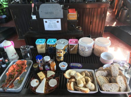 Gourmet breakfast buffet on a traditional Thai junk boat with bread, cheese, smoked salmon, and cereals