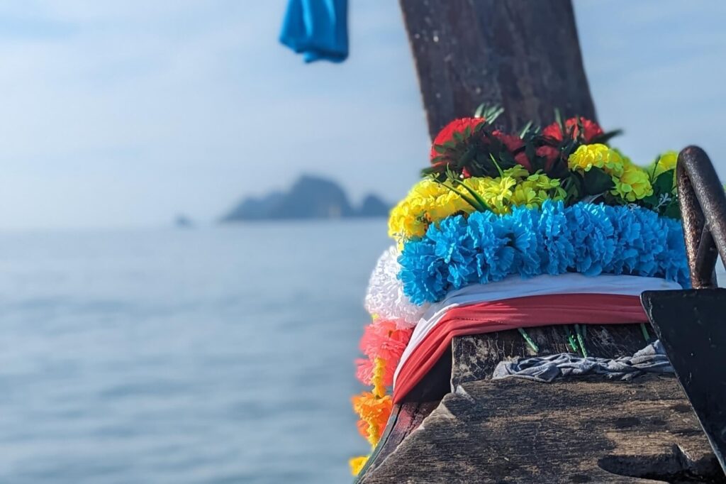 colourful flower decoration tied to the front of a longtail boat