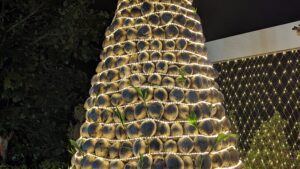 cocos apilados como un árbol de navidad y envueltos en luces de hadas