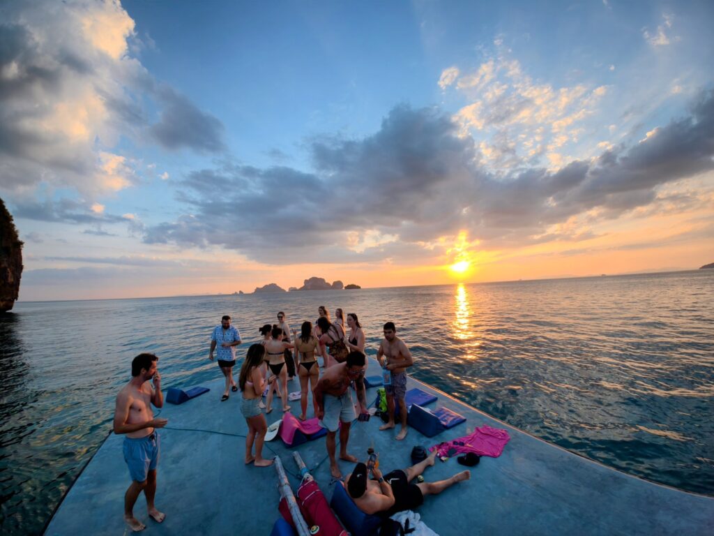 contiki group gathering on a boat top deck for sunset across krabi islands