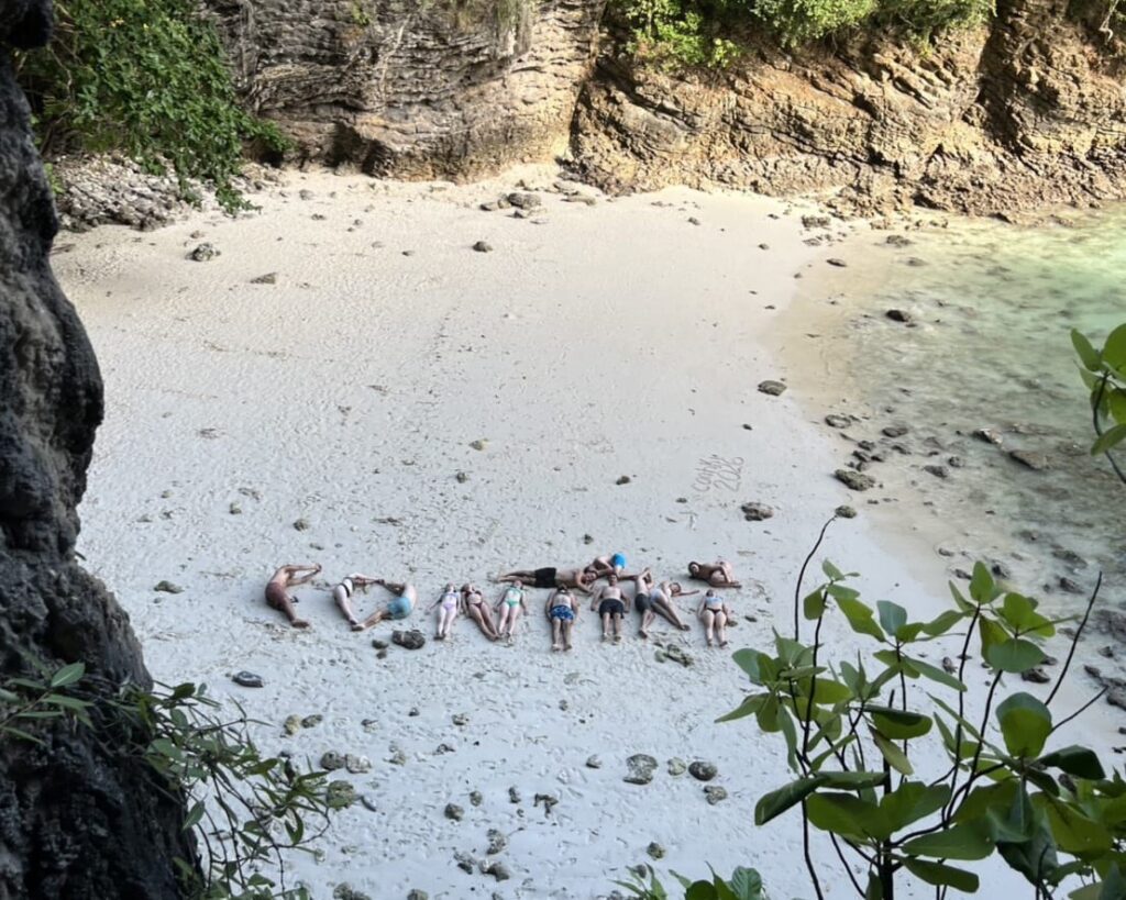 a birds eye view of people spelling out the word contiki on the beach with their bodies