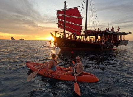 Kayaking at sunset with a junk boat in the background